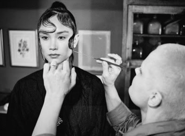 Karoliina slicking hair to models face